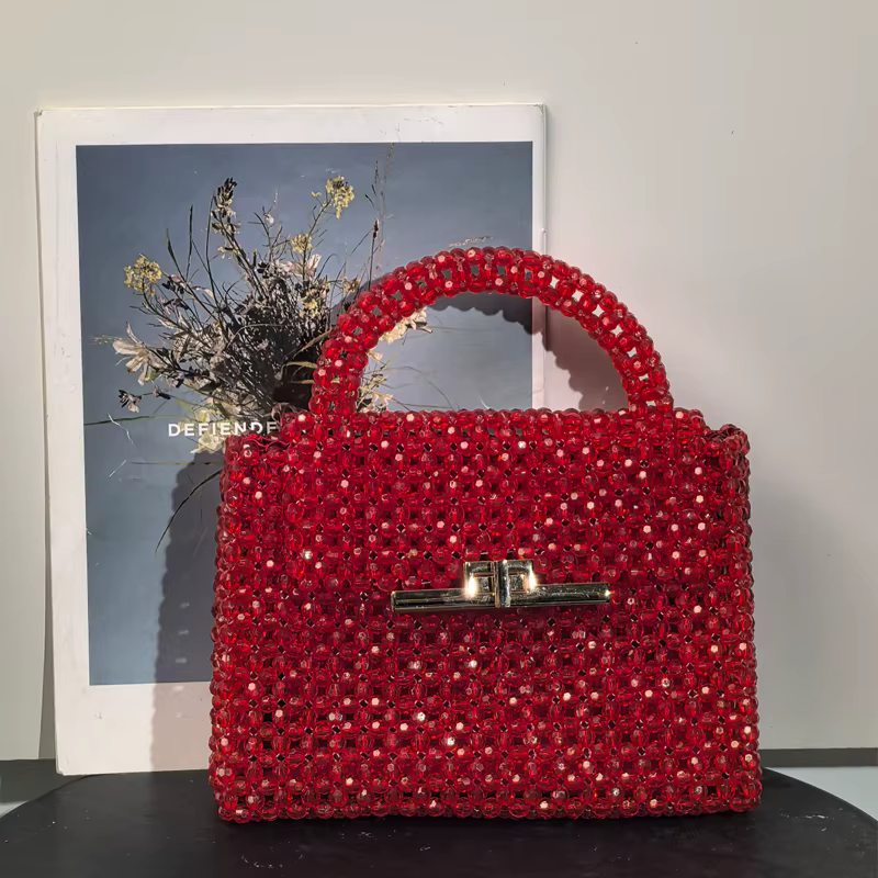 Un superbe sac à main en perles rouges avec un fermoir métallique chic qui évacue l'élégance et des