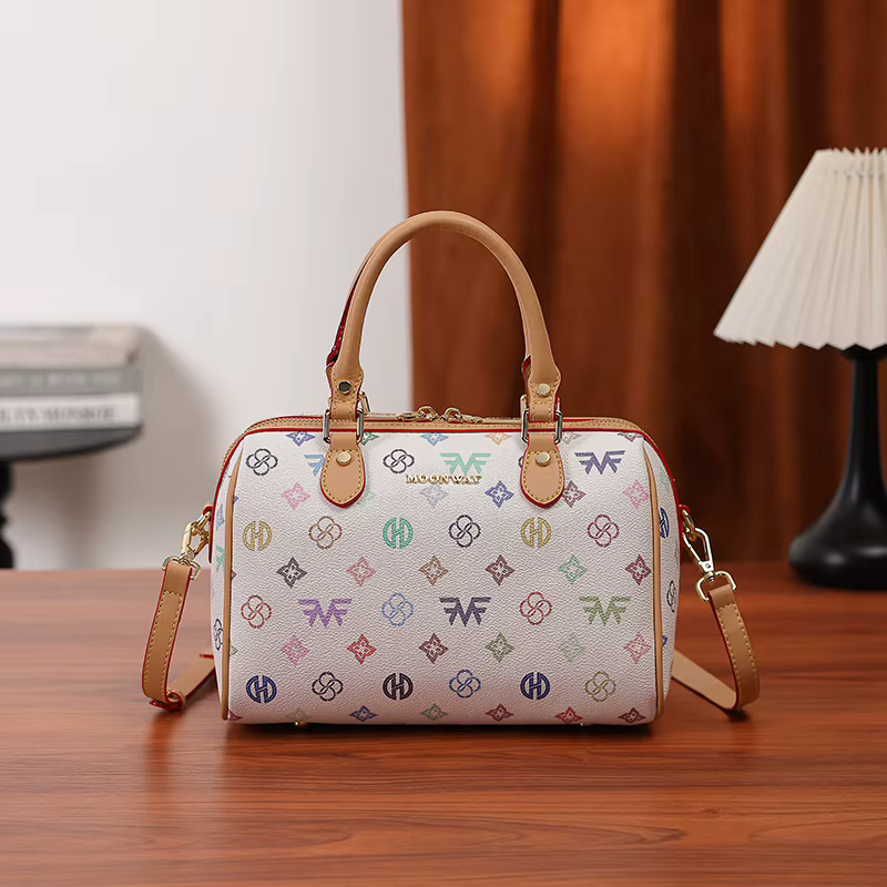 Sac à main cylindrique Boston de taille moyenne pour femme, avec un imprimé monogramme multicolore sur fond blanc, fermeture à glissière, poignée renforcée et large bandoulière réglable et amovible. D