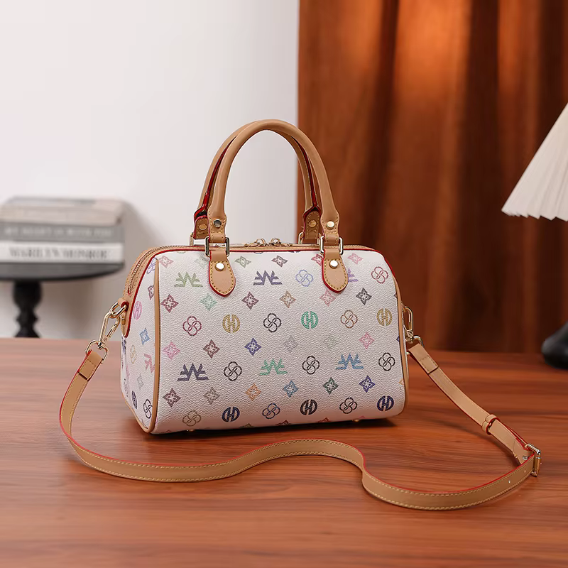 Sac à main cylindrique Boston de taille moyenne pour femme, avec un imprimé monogramme multicolore sur fond blanc, fermeture à glissière, poignée renforcée et large bandoulière réglable et amovible. D