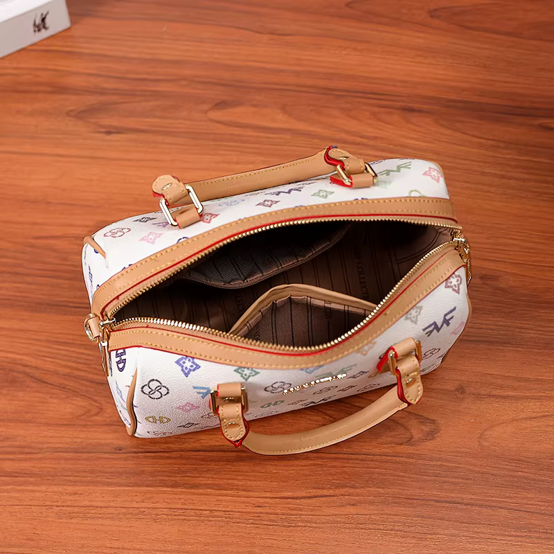 Sac à main cylindrique Boston de taille moyenne pour femme, avec un imprimé monogramme multicolore sur fond blanc, fermeture à glissière, poignée renforcée et large bandoulière réglable et amovible. D
