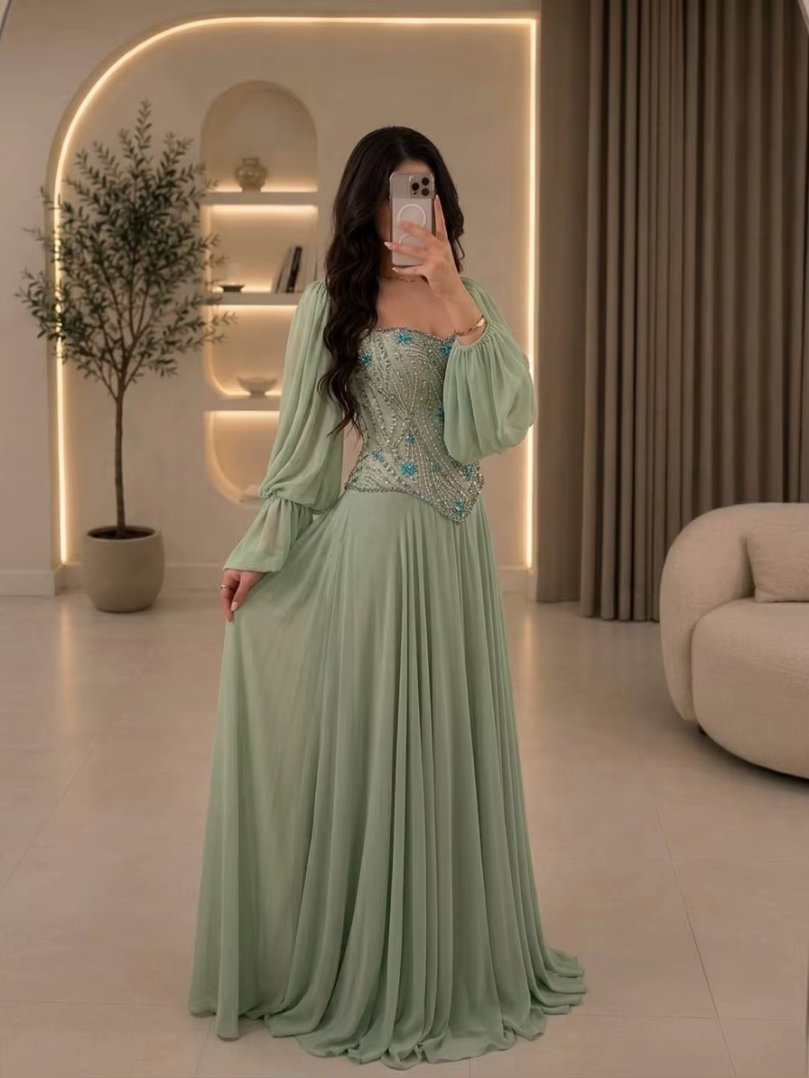 Robe de demoiselle d'honneur pour mariage au jardin à Dubaï, style henné |   Robe en mousseline de soie vert sauge, épaules dénudées, manches longues bouffantes, ornée de cristaux bleus cousus main