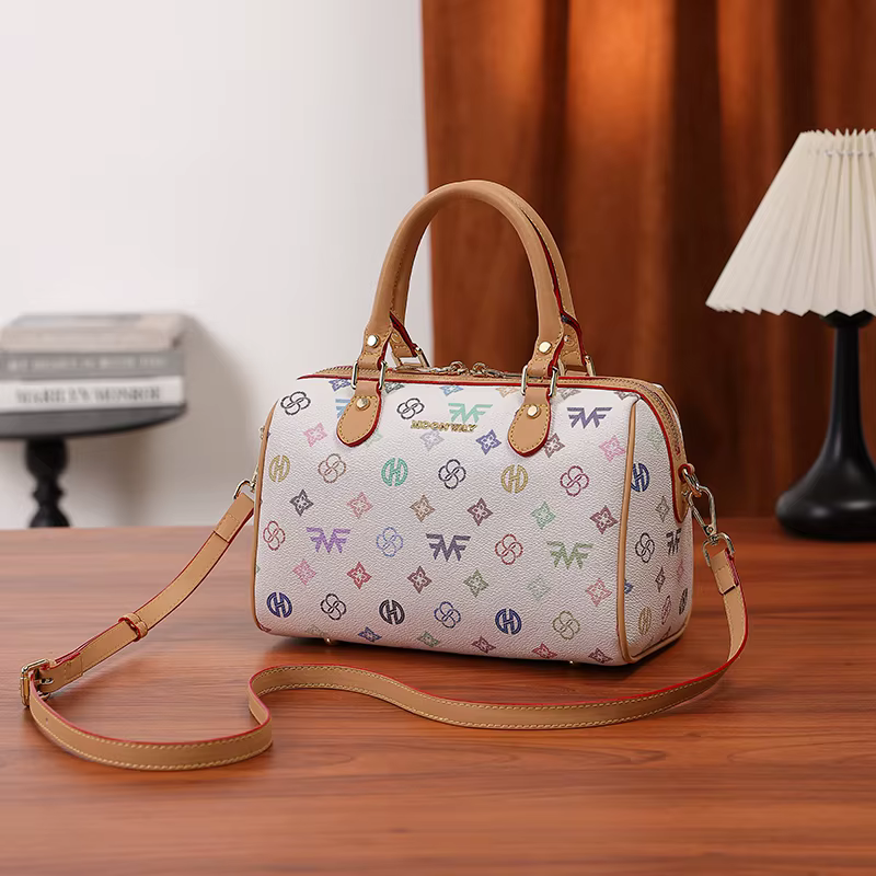 Sac à main cylindrique Boston de taille moyenne pour femme, avec un imprimé monogramme multicolore sur fond blanc, fermeture à glissière, poignée renforcée et large bandoulière réglable et amovible. D