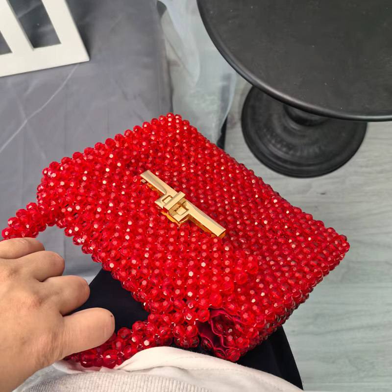 Un superbe sac à main en perles rouges avec un fermoir métallique chic qui évacue l'élégance et des sacs à main de luxe de déclaration avant-gardiste vintage