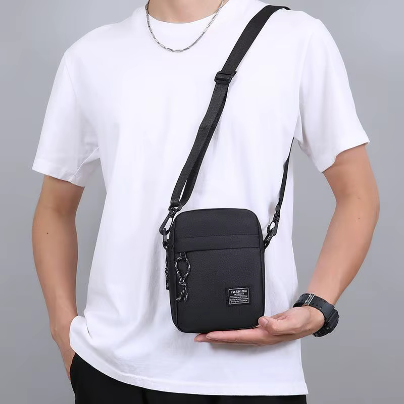 Sac pour homme, disponible en version à porter à l'épaule ou en bandoulière, adapté à un usage quotidien pendant l'école. Fabriqué en nylon
